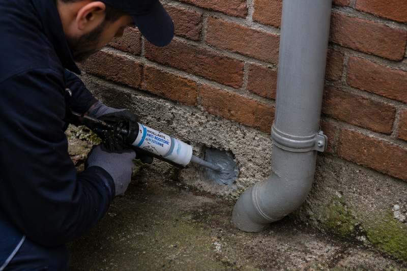 operatore sigilla buco nel muro